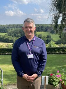 Andy Makin smiling standing in front of the Crimple viaduct.