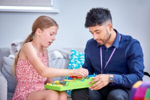 Just 'B' support worker playing a game with a girl